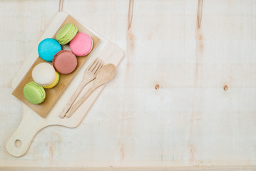The background is full of macarons decorated with ornamental plants.