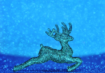 Obraz na płótnie Canvas Christmas deers on blue sparkling glitter background. Festive concept.