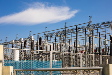 Fototapeta premium The outdoor power plant in the sunny day with the white clouds and blue sky.