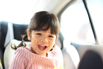 Little Child Girl wait and smiling on her Car Seat
