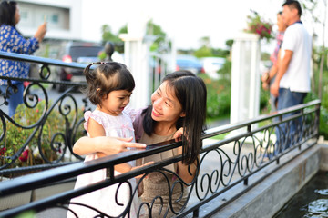 Little Girl and Mom Happy and Smile at The Garden