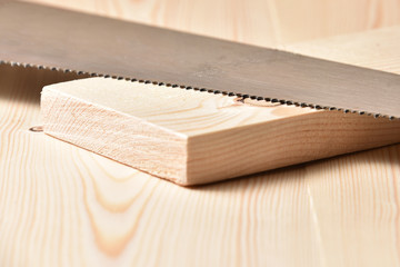 Hacksaw lies on a wooden bench