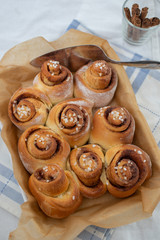 Cinnamon rolls with sugar frosting. With cinnamon sticks and spices, wooden background 