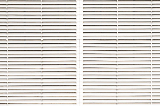 air ventilator ,metal slat frame on white ceiling, Industrial air duct ventilation equipment and pipe systems installed.