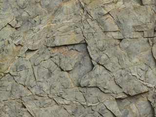 Rock formation texture. Grunge stone texture background. Fragment of a mountain with cracks and layers. Macro. Copy space for text or backdrop for design.