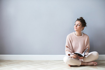 Idea. Young woman with a notepad is thinking.