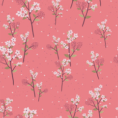 Seamless pattern of delicate flowers on branches with leaves and petals on a peach colored background