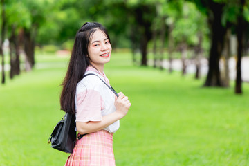 Asian cute girl teen smiling with braces teeth happy travel outdoor at green park background