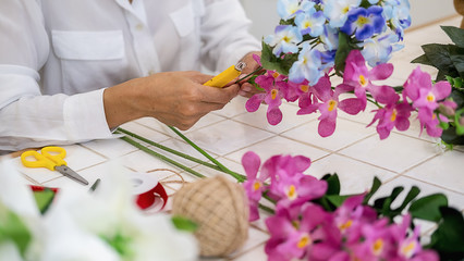 Woman hands making flower composition at florist workshop. Do it yourself concept.