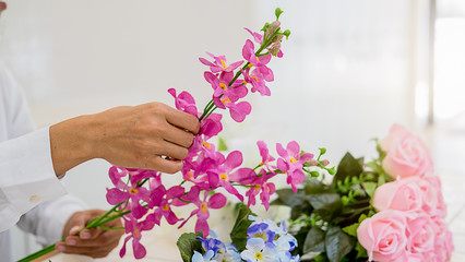 Woman hands making flower composition at florist workshop. Do it yourself concept.