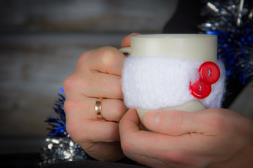 man holding winter cup close up on blurred background. man hands holding a cozy mug with hot cocoa, tea or coffee. Winter and Christmas time concept.hot drinks for winter season