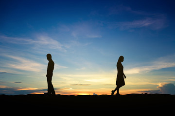 Silhouettes of couple man and woman broken heart at nature sunset. Love concept.