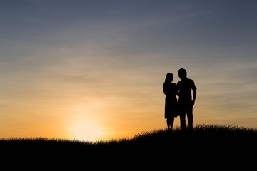 Obraz na płótnie Canvas Silhouettes of couple man and woman in nature sunset background. Love concept.