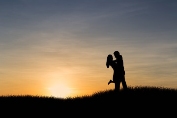 Fototapeta premium Silhouettes of couple man and woman in nature sunset background. Love concept.