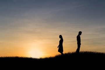 Silhouettes of couple man and woman broken heart at nature sunset. Love concept.