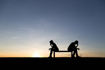Silhouettes of couple man and woman broken heart at nature sunset. Love concept.