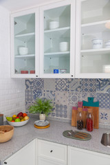 Fototapeta na wymiar Modern white kitchen with counter and white details, minimalist interior, Full set of kitchen equipment
