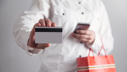 Girl using smartphone and holding credit card. Shopping