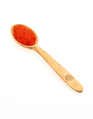 Red caviar in a wooden spoon close-up on a white background