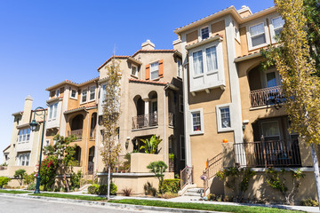Exterior view of multistory single family homes built close to one another in San Jose, Silicon Valley