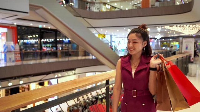 slow-motion of young woman walking with shopping bags in the mall