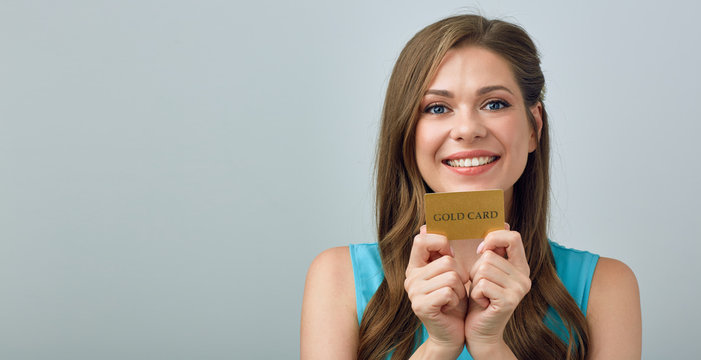 Happy woman with big toothy smile holding credit card near face.