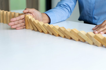 young business people use the hand to Stop wooden brick