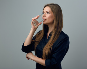 Young woman drinking water from glass.