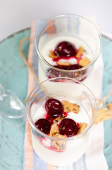 Natural yogurt, cookies and cherries served. Healthy dessert. Portion desert in glass. Copy space.