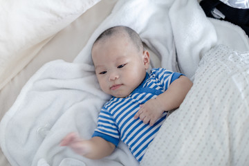 Adorable baby lying down on bed before sleep