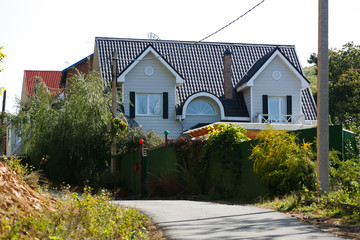 Beautiful country house behind a high fence. Chic cottage in a holiday village.