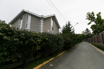 Beautiful country house behind a high fence. Chic cottage in a holiday village.