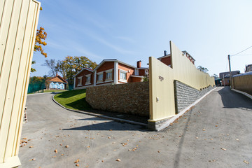 Beautiful country house behind a high fence. Chic cottage in a holiday village.