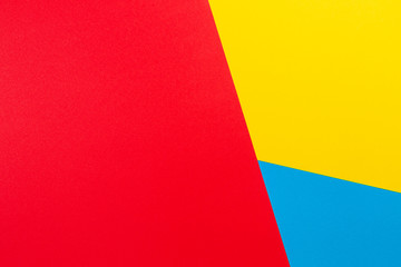 Color papers geometry flat composition background with yellow red and blue tones