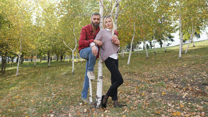 Husband and wife in park near birch. Concept of seasoned love