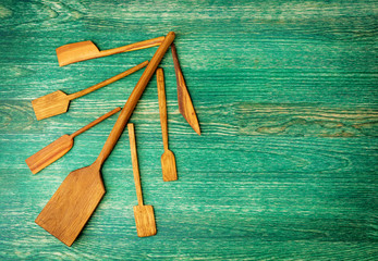 Christmas tree made from wooden kitchen tools on green wooden background with copy space. Flat lay background