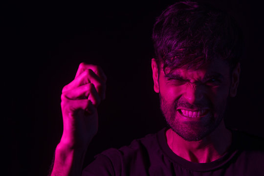 portrait of an angry man with clenched teeth in red	