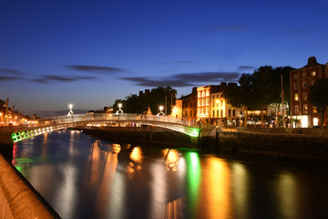 Fototapeta na wymiar Dublin, Ireland. Night view of famous illuminated Ha Penny Bridge in Dublin, Ireland, at sunset