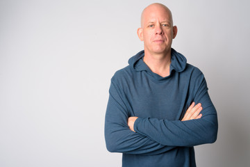 Portrait of mature handsome bald man with arms crossed