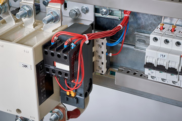 The electrical wires are connected to the side additional contacts of a powerful contactor or magnetic starter in the electrical Cabinet. Automation, uninterrupted power supply. Right circuit breaker.