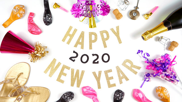 2020 Happy New Year's Eve banner on white background with champagne and pink and gold party decorations flatlay.