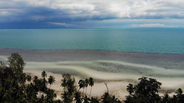 Unusual coast of white sand. Breathtaking landscape of sandy wavy seaside. Paradise islands in Asia. Drone view, natural idyllic scene, coconut palms on the beach. Thunderstorm in the tropics