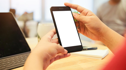 Cropped shot view of man hands holding smart phone with blank copy space screen for your text message or information content, female reading text message on cell telephone during in urban setting. 