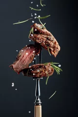 Deurstickers Grilled ribeye beef steak with rosemary on a black background. © Igor Normann