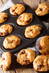 muffins with sun-dried tomatoes and cheddar cheese close-up in a baking dish on the table. vertical