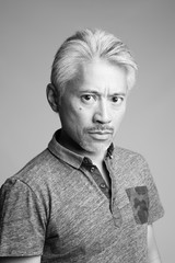 Retrato de un hombre de origen asiático, hombre de mediana edad, con pelo blanco, mirando con cara de preocupación