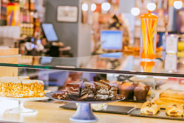 Cakes in the showcase of a cool coffee shop. Small business concept.