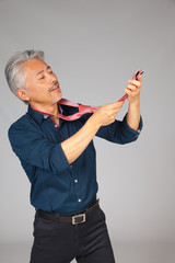 Hombre de mediana edad de origen japonés, seleccionando una corbata, dudando que corbata ponerse