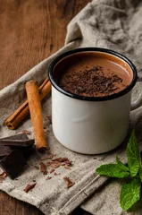Deurstickers cup of hot chocolate, cinnamon sticks, mint and chocolate on wooden © Anton