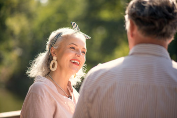 Good-looking mature woman wearing nice earrings looking at husband